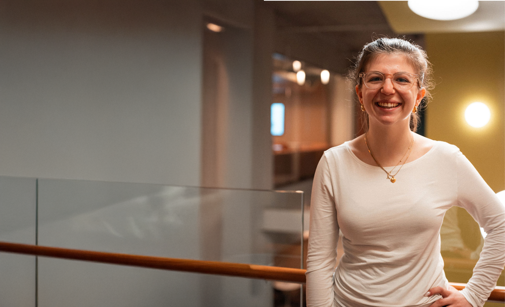 An Adler University student smiles by a staircase at the Chicago campus.